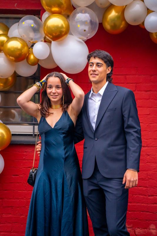 Bal de la promo 2029 — portrait d'un couple en tenue de soirée devant l'arche de ballons