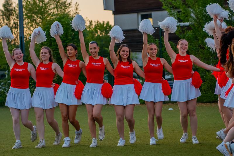 Pom-pom girls ENSCL — ligne d'équipe pompons levés au coucher de soleil